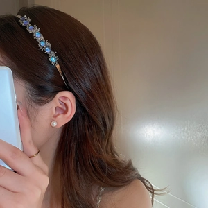 Detail showing elegant headband with blue purple gems and matching pearl earrings