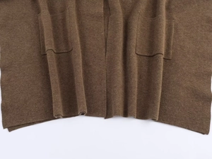 Detailed view of coffee brown knitted shawl featuring two symmetrical front patch pockets