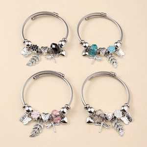 Detail view of four beaded wire cable bracelets with butterfly and heart charms