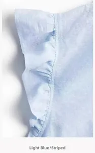 Detail of light blue striped linen blouse featuring elegant ruffle sleeve texture