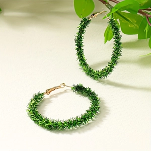 Minimalist green plush hoop earrings with gold-toned buckles on a natural background