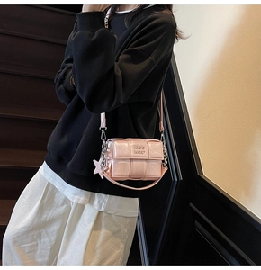 Détail d'un sac bandoulière tressé rose avec pendentif étoile et chaîne en argent
