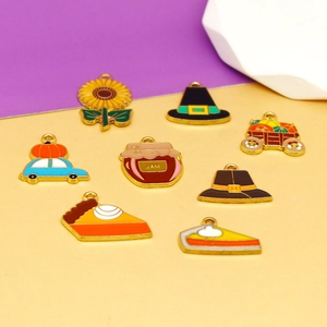 Detailed macro view of Thanksgiving enamel charms including pumpkins and turkey motifs