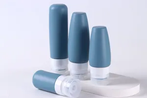 Close-up of Morandi blue silicone travel bottles in 100ml and 60ml sizes on white pedestals