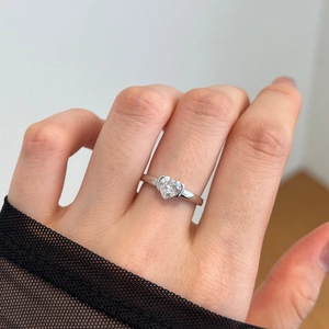 Close-up of a silver heart-shaped zircon ring worn by a model with elegant black lace detail