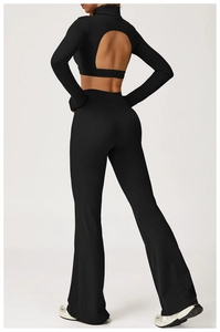 Détail du haut de yoga noir dos nu à manches longues et du legging évasé coupe ajustée