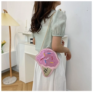 Girl wearing a pink ice cream shaped crossbody bag with sequins and gold chain strap