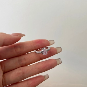 Detailed macro view of an oval pink crystal ring with sparkling surrounding side diamonds