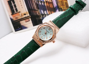 Detail of green leather strap and rose gold octagonal diamond-set case on quartz watch