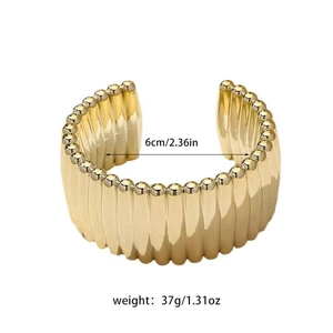 Detail of gold ribbed cuff bracelet showing dimensions of 6cm inner diameter and weight