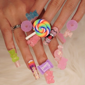 Colorful candy-themed press-on nails with 3D gummy bears and rainbow lollipop charms