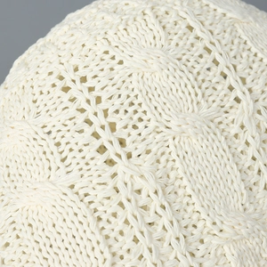 Gros plan sur la maille torsadée blanche d'un chapeau cloche en laine élégant