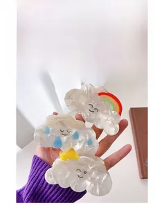 Detailed view of handmade acetate cloud hair claws with rainbow and sun charms set