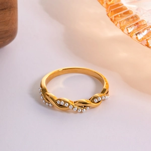 Detail of gold twisted rope ring with white micro pearls on a decorative tray