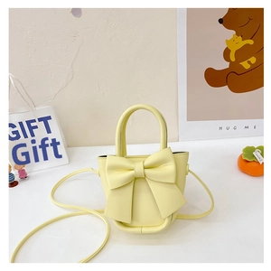 Close-up of a pale yellow mini bow crossbody bag with soft PU leather texture