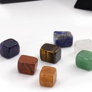 Close-up of seven polished natural crystal cubes in various vibrant gemstone colors