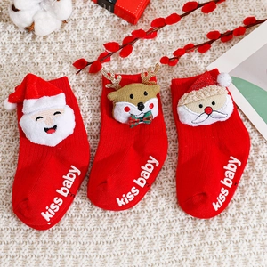 Festive red Christmas baby socks with Santa and Reindeer embroidery on knit background