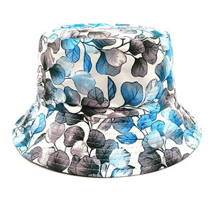 Close-up of blue botanical leaf print on a reversible bucket hat with reinforced stitching