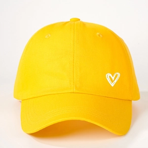 Texture détaillée de la casquette jaune en coton avec un motif de cœur blanc imprimé