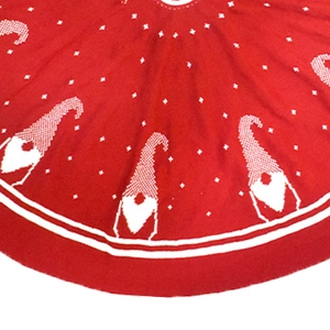 Close-up of red knitted Christmas tree skirt with white gnome patterns and star details