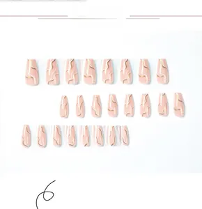 Detail view of pink press-on nails with white and gold marble wave pattern in coffin shape