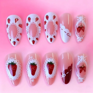 Sweet strawberry press-on nails with bow and pearl accents in long almond shape