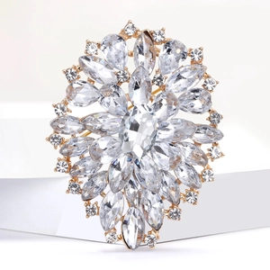 Macro shot of a floral alloy brooch with sparkling rhinestones and a large oval center gem