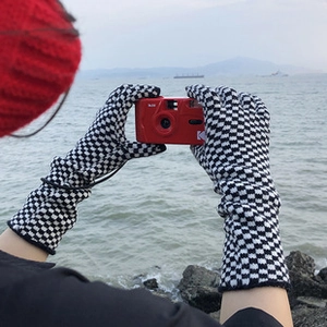 Long knit gloves with black and white checkered pattern and touchscreen thermal material