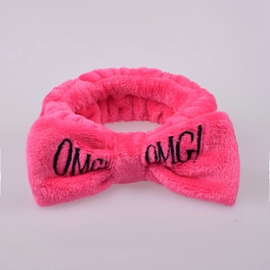 Close-up of pink plush headband with embroidered OMG bow for washing face