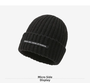 Close-up of thick knit black beanie featuring a unique fabric patch and textured details