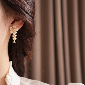 Close-up of shell flower earrings with zircon water drop tassels on a model