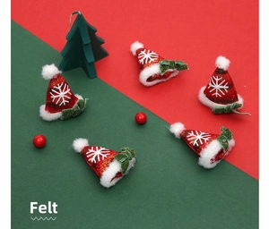 Close-up of five handmade wool felt Christmas mini hats with snowflakes and green bows