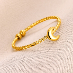 Macro detail of gold-plated twisted rope bracelet with a polished crescent moon charm