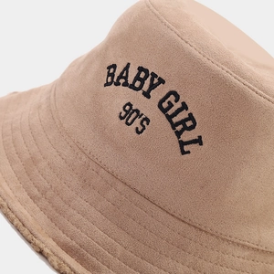 Close-up of embroidery text BABY GIRL and 90'S on suede winter bucket hat fabric