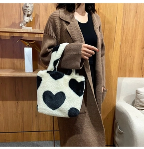 Close-up of black and white plush bucket bag with large heart pattern and soft texture