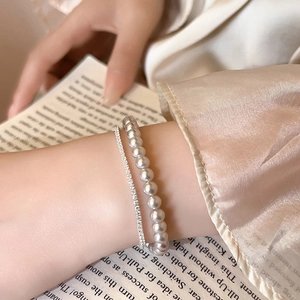 Detail of double-layer pearl and zircon bracelet with elegant silver plating and draping