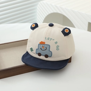 Close-up of baby baseball cap with car embroidery and soft navy brim on a tray