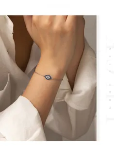 Gros plan du bracelet mauvais œil en argent S925 avec zircons bleus au poignet féminin