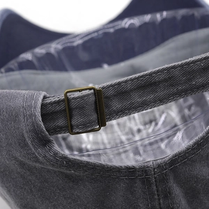 Detail of adjustable brass buckle and reinforced stitching on washed cotton baseball cap