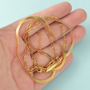 Detail of gold double layer snake and paperclip link chain necklace with lobster clasp