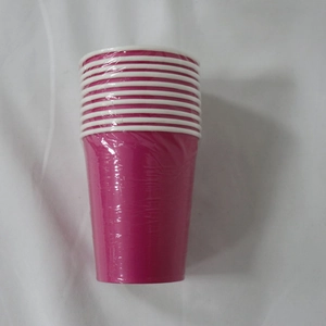 Stack of twelve pink disposable paper cups with white rims in plastic wrap packaging