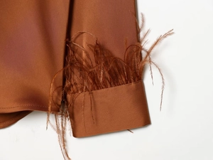 Elegant brown silk blouse featuring luxurious feather trim cuffs in a relaxed urban fit