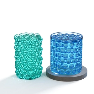 Detailed view of textured cylindrical resin candle molds with bubble and honeycomb patterns