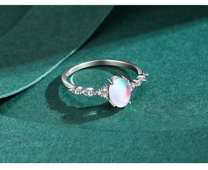 Macro detail of oval moonstone ring with marquise side stones on dark texture