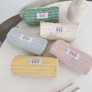 Primer plano de estuches de tweed coloridos con etiquetas de tulipán y cremalleras