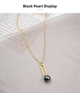 Detail of gold necklace featuring a minimalist brushed oval link and a round black pearl