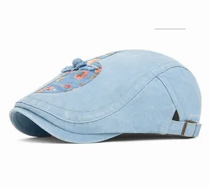 Detail der hellblauen Schiebermütze aus Denim mit floralem Patchwork und Metallschnalle
