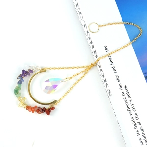 7 Chakra crystal moon suncatcher with rainbow teardrop pendant on minimalist book background