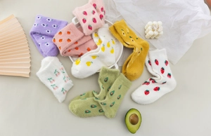 Flat lay of soft mink velvet winter socks with cute strawberry and cherry patterns