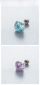 Macro detail of sky blue and lavender zircon earrings with polished titanium steel studs
